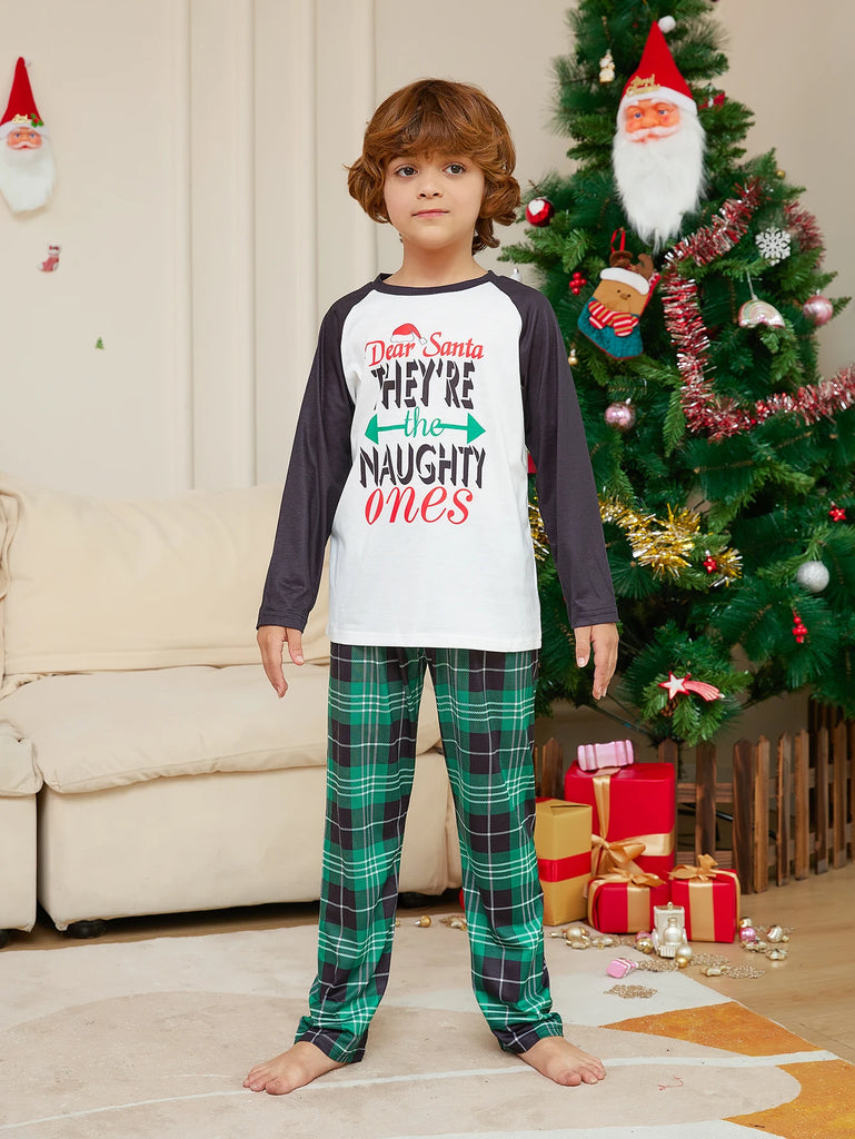 Matching family pyjamas with a playful Naughty or Nice theme, ideal for festive photos.